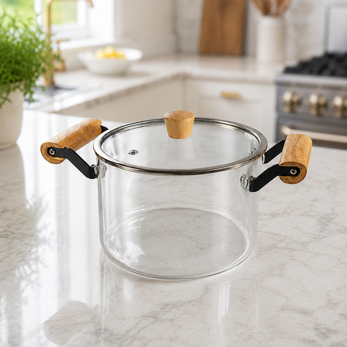 Olla de vidrio de borosilicato con asas de madera y tapa, sobre mesada de mármol