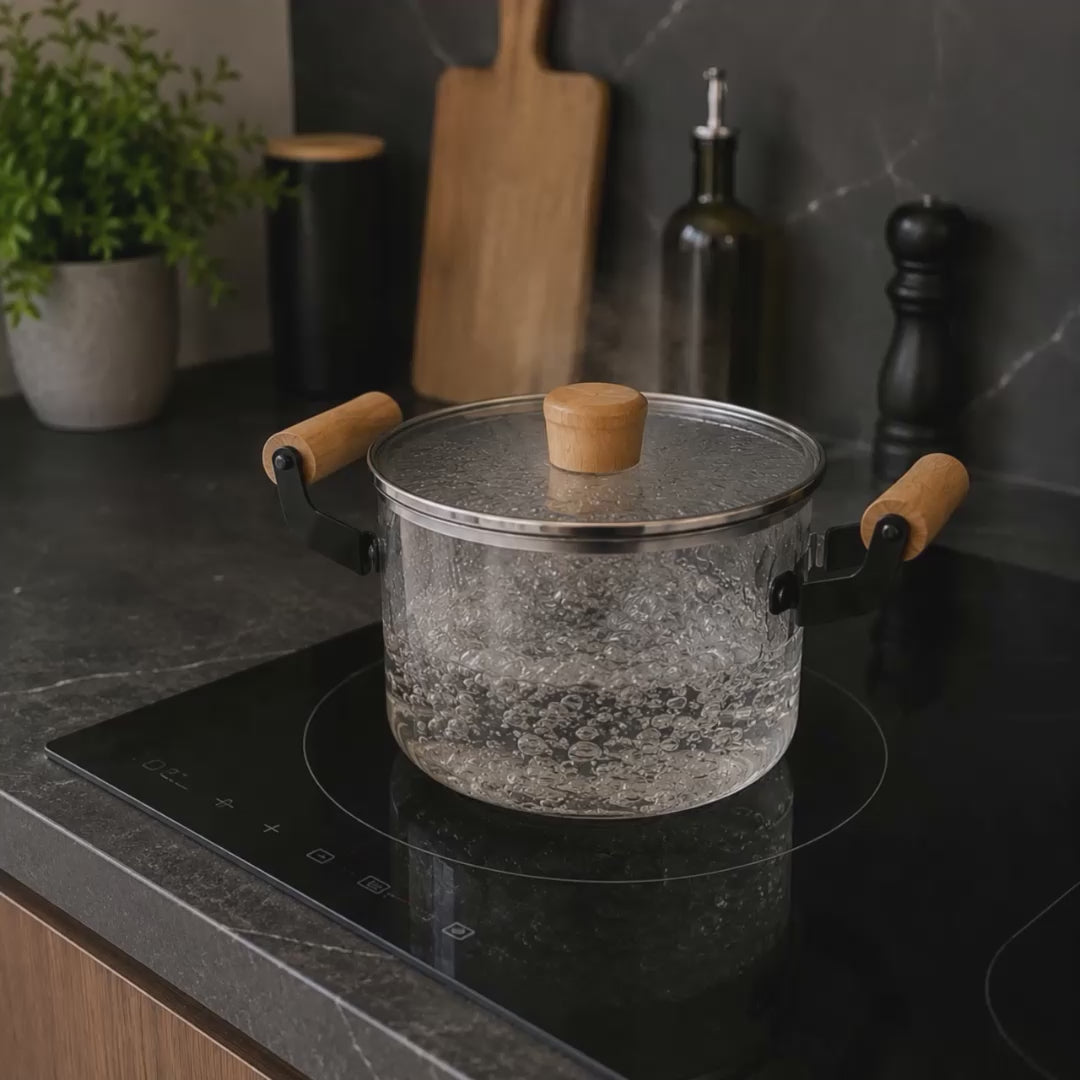 Olla de vidrio con asas de madera en uso: hirviendo agua, destapado y cocción de fideos